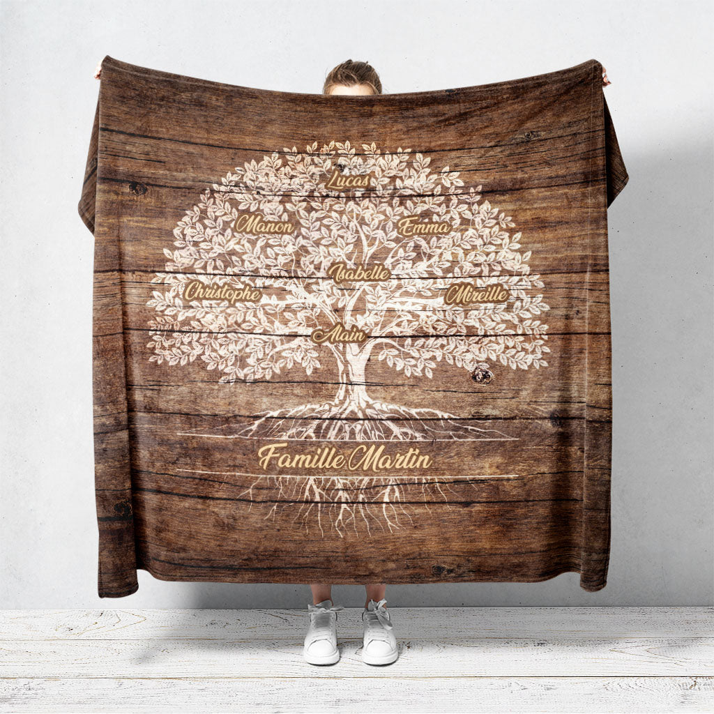 Un plaid personnalisé famille qui représente un Arbre de vie personnalisé peint en blanc sur de vielles planches de bois. Les prénoms et les textes sont personnalisables.