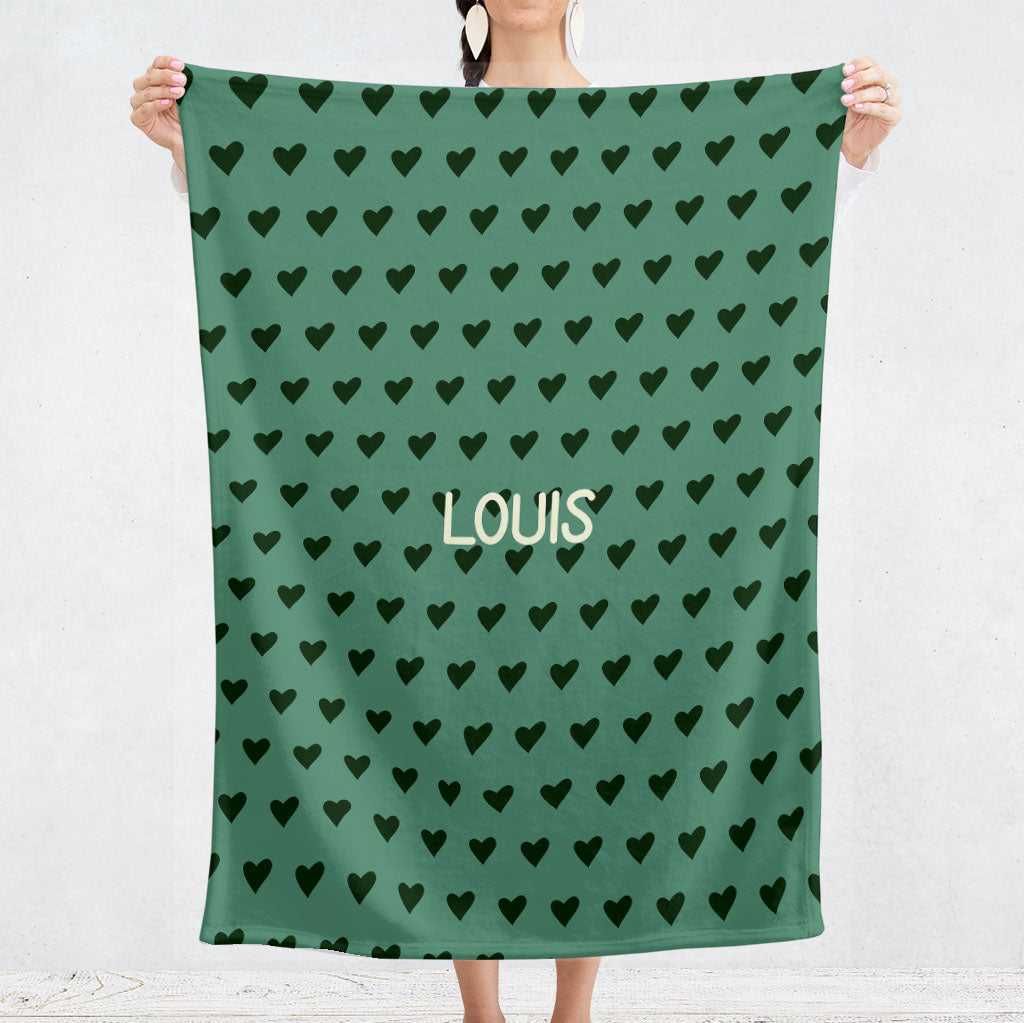 Un plaid bebe personnalisé pour les naissance au motif de coeurs noirs avec un fond de couleur vert. Ce plaid est aussi bien pour la naissance d'une fille que d'un garçon. Le prénom est personnalisable.