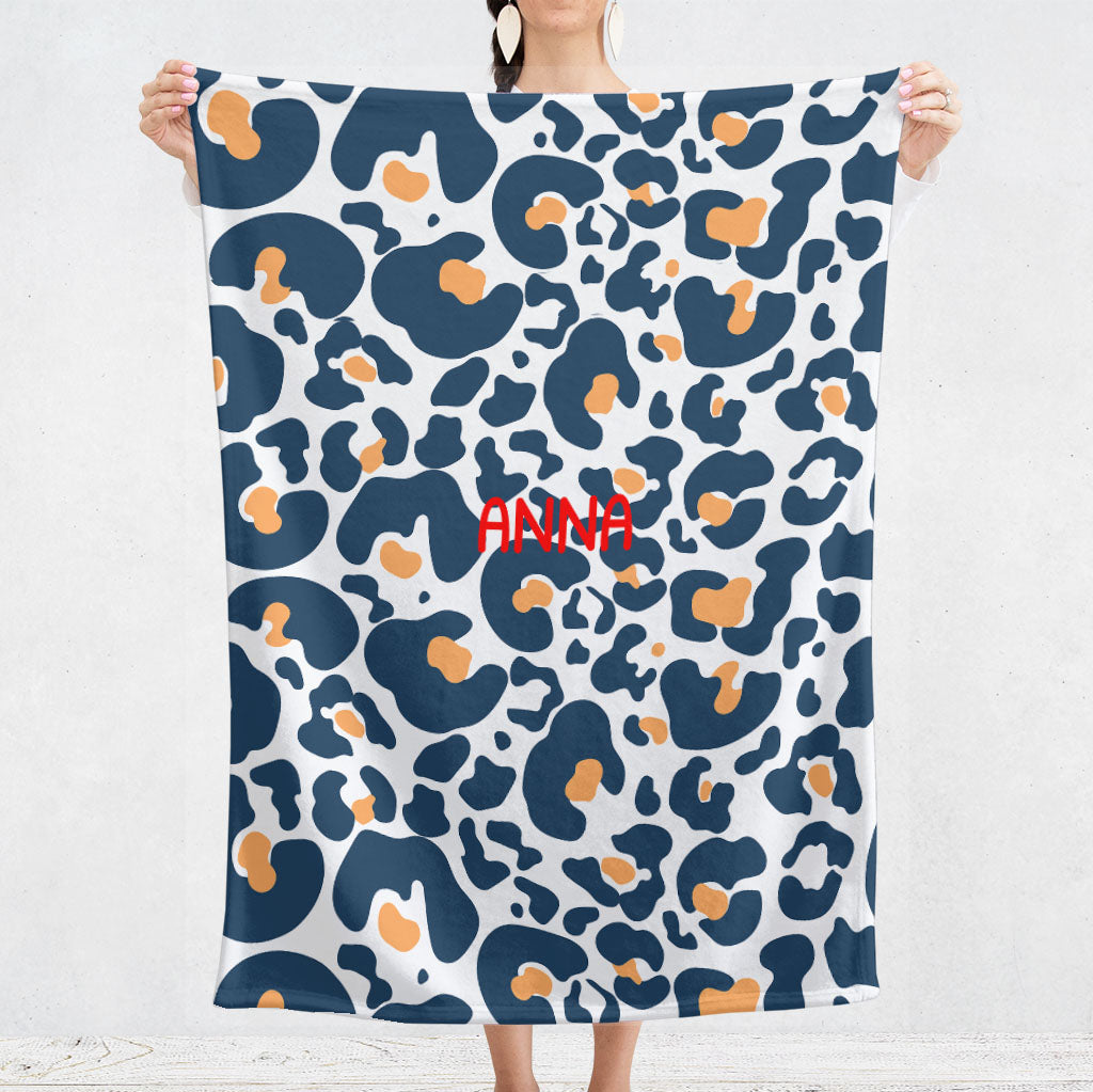 Un plaid bebe personnalisé pour les naissance au motif lépoard bleu et jaune avec un fond de couleur blanc. Ce plaid est aussi bien pour la naissance d'une fille que d'un garçon. Le prénom est personnalisable.