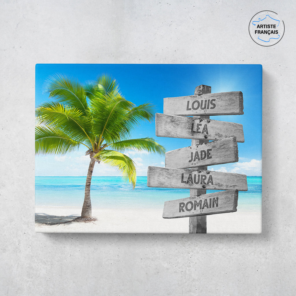Un tableau personnalisé famille qui représente des panneaux de direction en bois avec des prénoms inscrit dessus, au bord d’une plage tropicale et son palmier. Les prénoms sur les panneaux sont personnalisables.
