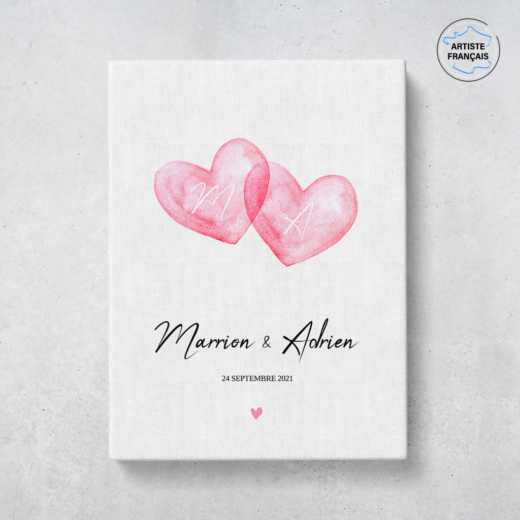 Un tableau personnalisé couple qui représente deux coeurs en aquarelle roses qui se touchent sur un fond blanc. Les prénoms et la date de rencontre du couple sont personnalisables. Le design est minimaliste.