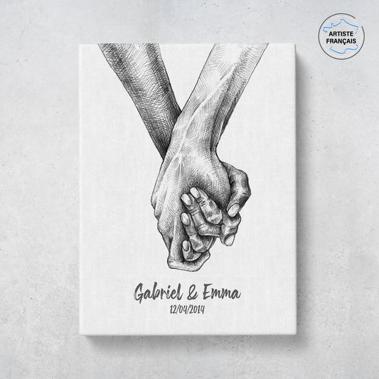 Un tableau personnalisé couple qui représente deux mains qui s’enlacent dessinées au fusain sur un fond blanc. Les prénoms et la date de rencontre du couple sont personnalisables. Le design est minimaliste.