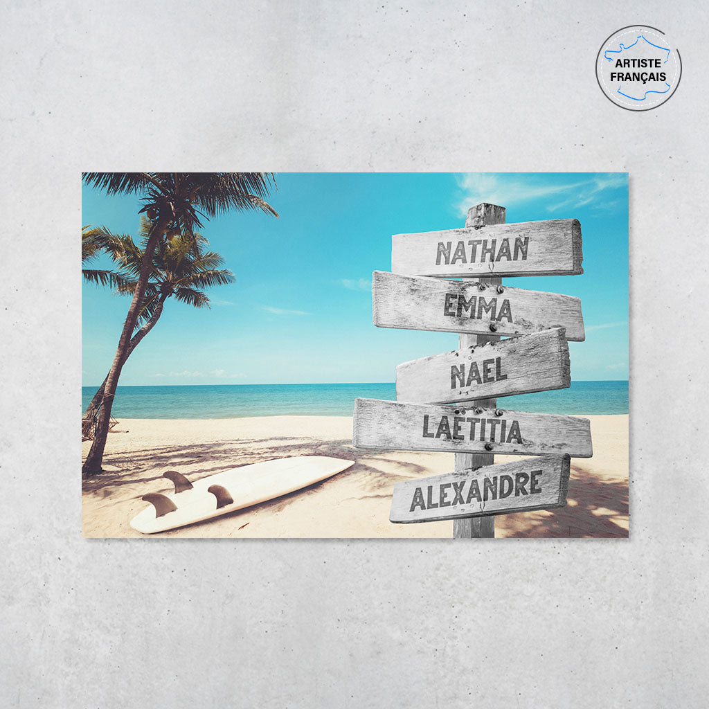 Une affiche personnalisée famille qui représente des panneaux de direction en bois avec des prénoms inscrit dessus au bord d’une plage tropicale, une mer bleue claire, un palmier et une planche de surf. Les prénoms sur les panneaux sont personnalisables.
