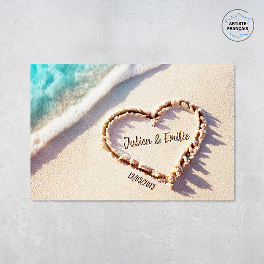 Une affiche personnalisée couple qui représente un coeur dessiné dans le sable d’une plage avec les prénoms du couple et leur date de rencontre . Les prénoms et la date de rencontre du couple sont personnalisables.