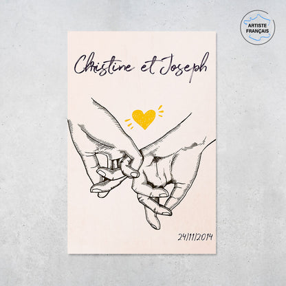 Une affiche personnalisée couple représentant deux mains dessinées au fusain qui enlacent leur petit doigt en signe d’amour avec un fond et un coeur central aux couleurs pastelles. Les prénoms du couple, la date de rencontre et les textes sont personnalisables.