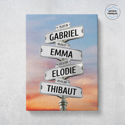 Un tableau personnalisé famille qui représente des panneaux de direction de ville sous un ciel nuageux avec un coucher de soleil . Les prénoms et dates de naissances sur les panneaux sont personnalisables.