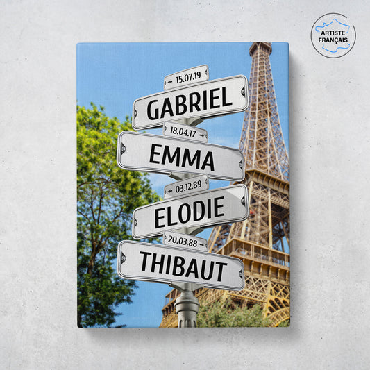 Un tableau personnalisé famille qui représente des panneaux de direction de la ville de Paris avec la tour Eiffel et un arbre. Les prénoms et dates de naissances sur les panneaux sont personnalisables.