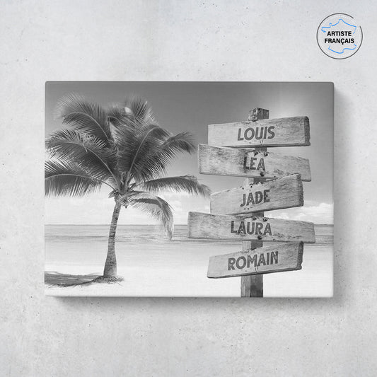 Un tableau personnalisé famille qui représente des panneaux de direction en bois avec des prénoms inscrit dessus, au bord d’une plage tropicale et son palmier en noir et blanc. Les prénoms sur les panneaux sont personnalisables.