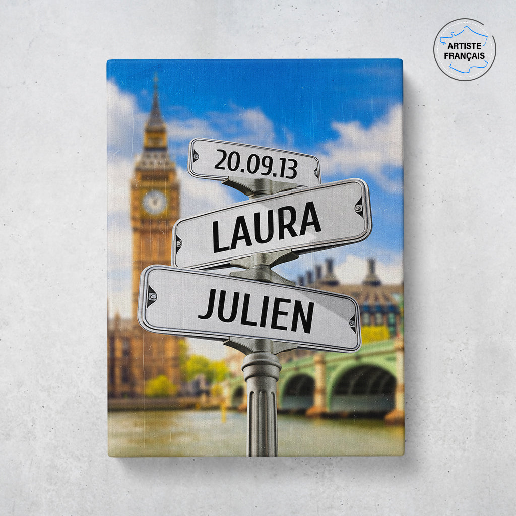 Un tableau personnalisé couple représentant des panneaux de direction de la ville de Londres avec Big Ben en arrière plan. Les prénoms du couple, la date de rencontre et les textes sont personnalisables.