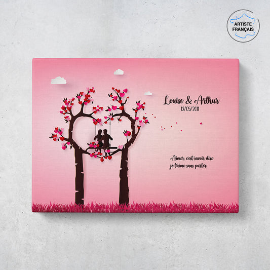 Un tableau personnalisé couple représentant un couple en Papercraft faisant de la balançoire sur un arbre en forme de coeur sur fond rose. Les prénoms du couple, la date de rencontre et le texte sont personnalisables.