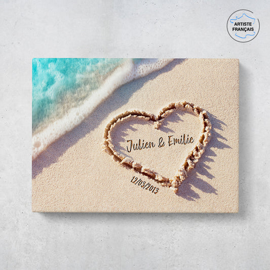 Un tableau personnalisé couple qui représente un coeur dessiné dans le sable d’une plage avec les prénoms du couple et leur date de rencontre . Les prénoms et la date de rencontre du couple sont personnalisables.