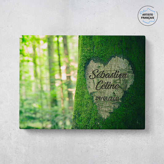 Un tableau personnalisé couple qui représente un tronc d’arbre recouvert de mousse verte ou un coeur est gravé dessus. Les prénoms gravés au centre du coeur et la date de rencontre du couple sont personnalisables.